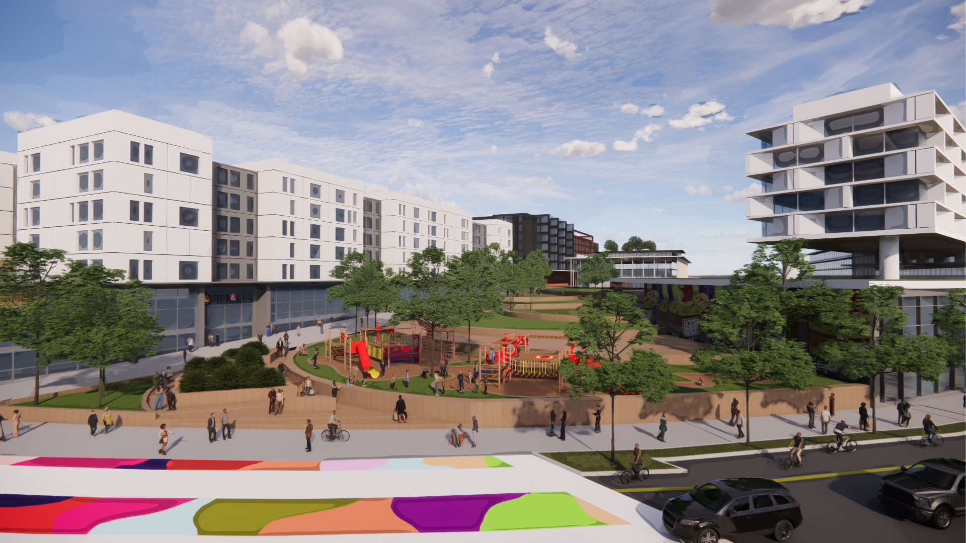 Rendering of buildings and playground in the background with a colorful street graphic in foreground