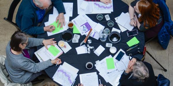 View from above of people at a table during the National Center for Smart Growth (NCSG), Purple Line Corridor Coalition (PLCC) event in March 2019.