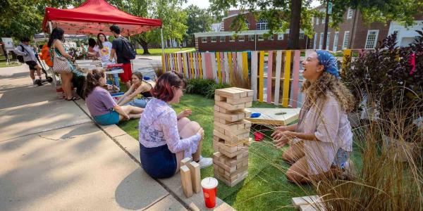 Student organization students laughing while playing jenga.