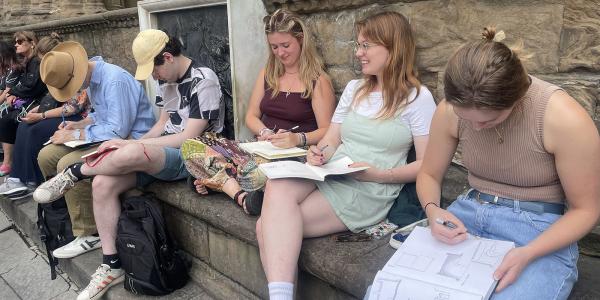 Students drawing on sketchbooks in Italy