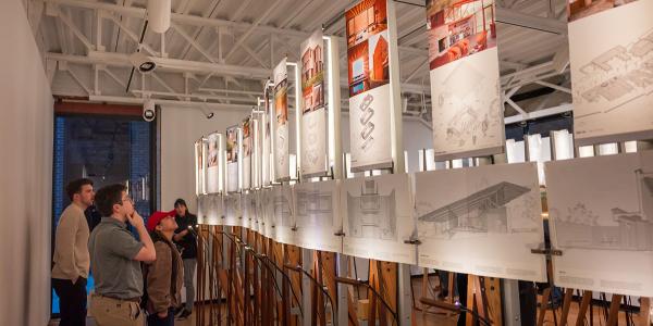 Students looking up at panels lit at an exhibition