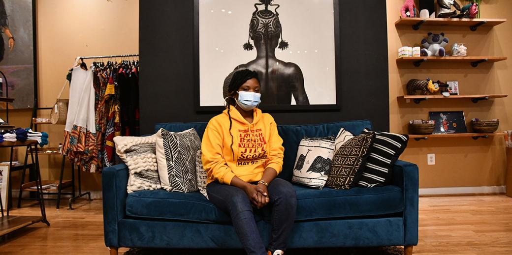 Anika Hobbs sitting on a couch in the Nubian Hueman clothing store.