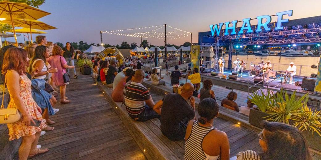 People gathered around an outdoor concert at the Wharf in DC.