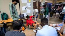 Student testing a cardboard chair