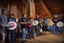 Chinook People playing instruments at plankhouse.