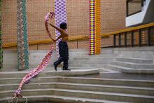 A woman dancing with long strands of fabric