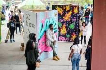 People by walls of grafitti art at the Broccolli City Festival