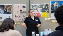 Student presenting with Terp's Voting posters behind her 