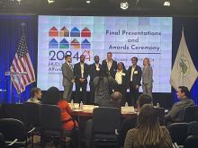 Students standing on stage for the HUD presentation