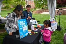 A child playing with a toy toilet to learn about waste management.