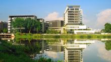 Tall building by the water and reflected in the pond