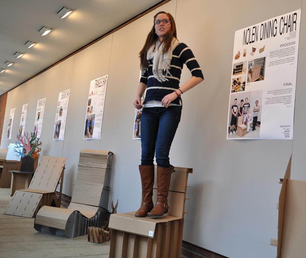 Betsy Nolen, GA for ARCH270, tests the integrity of a team's chair design.