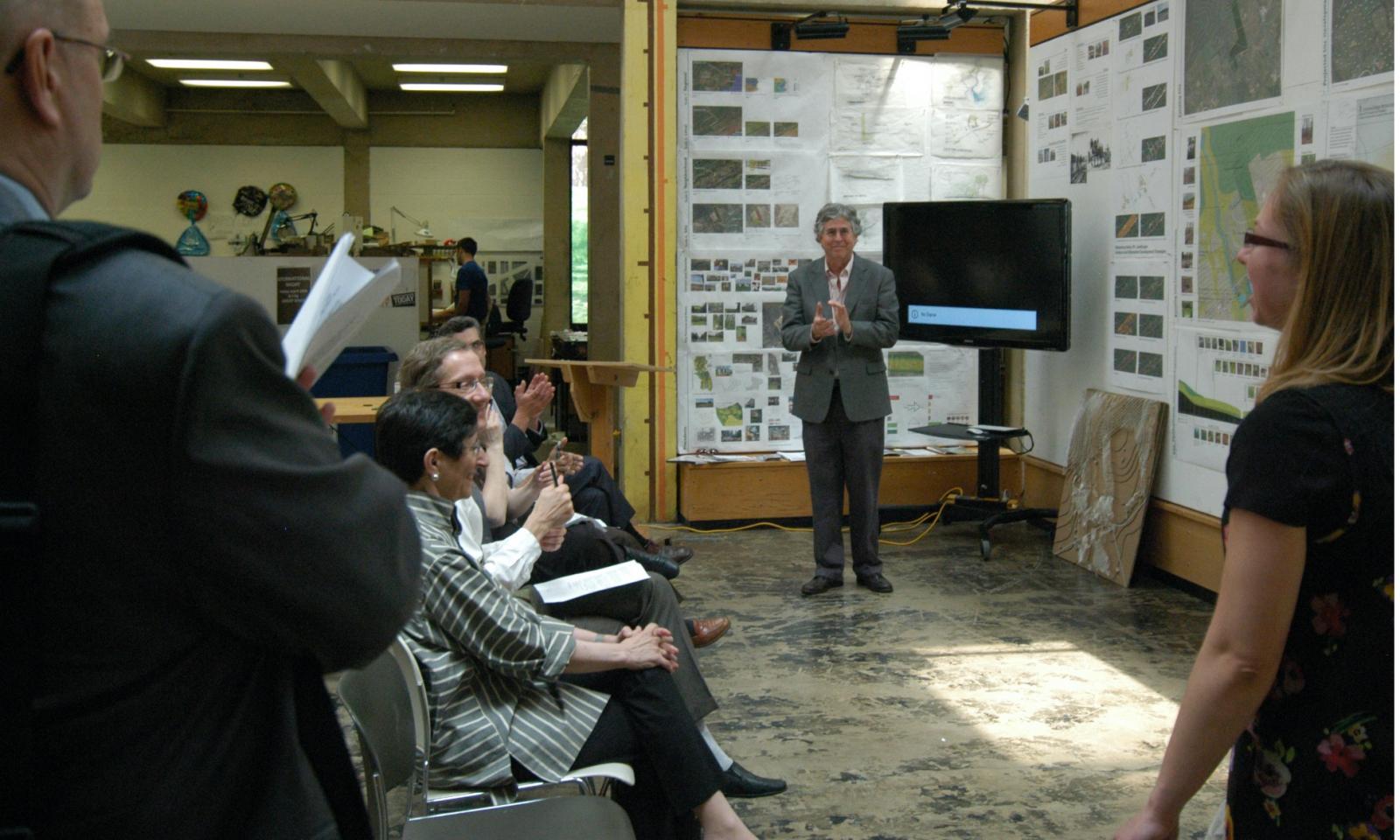 Carl Bovill clapping at a thesis presentation.