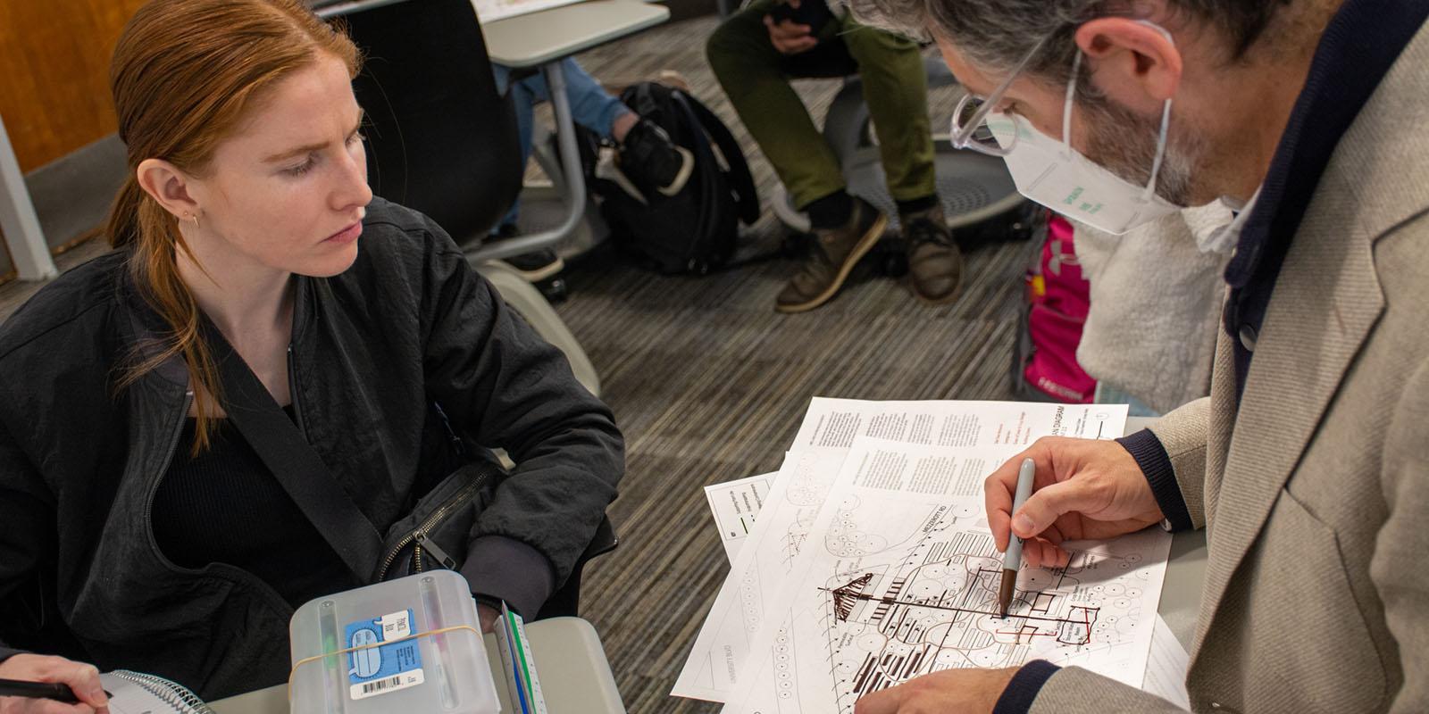 Student going over her architecture designs with her professor.