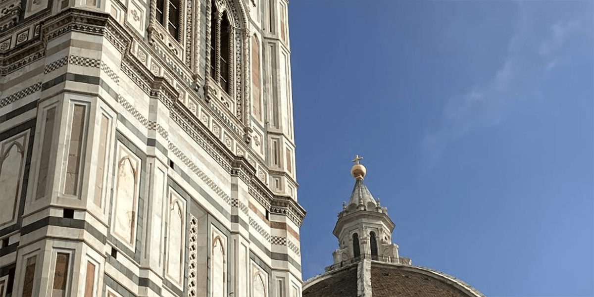 Side of a building and top of a church in Florence Italy.