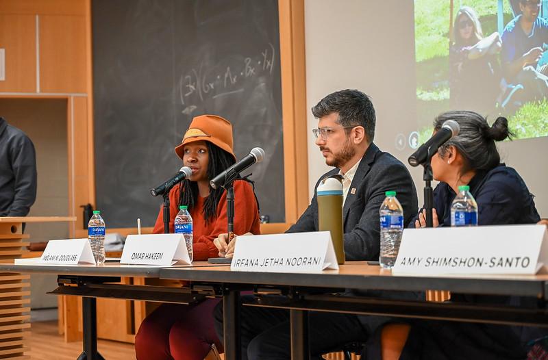 A woman in a hat and two other panelists talking