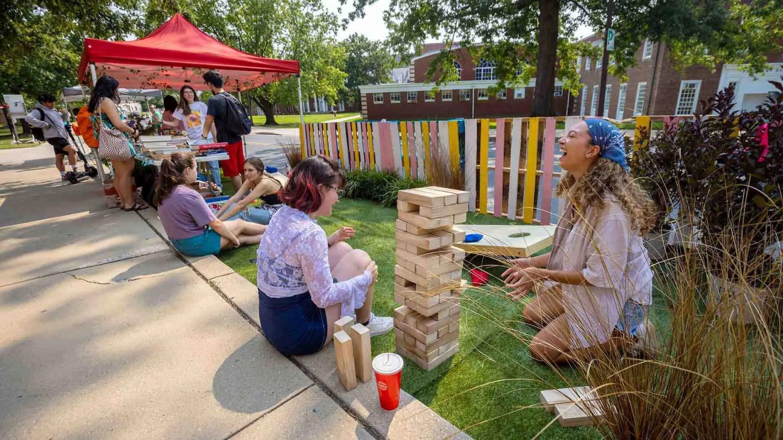 Student organization students laughing while playing jenga.