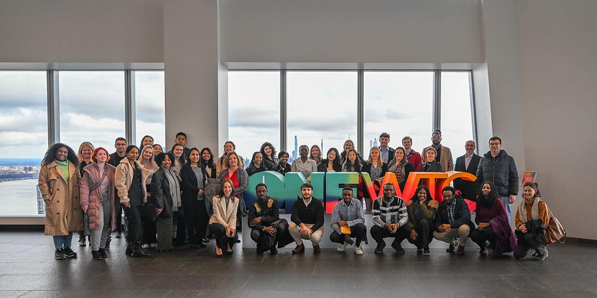 Group shot in front of colorful ONE WTC sign