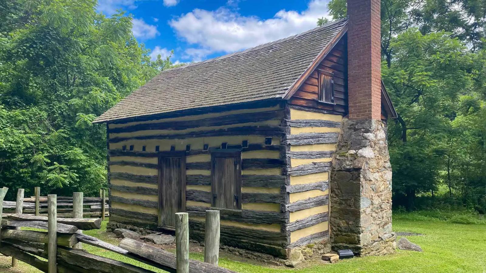 Oakle Cabin made of wooden logs and a stone and brick chimney.