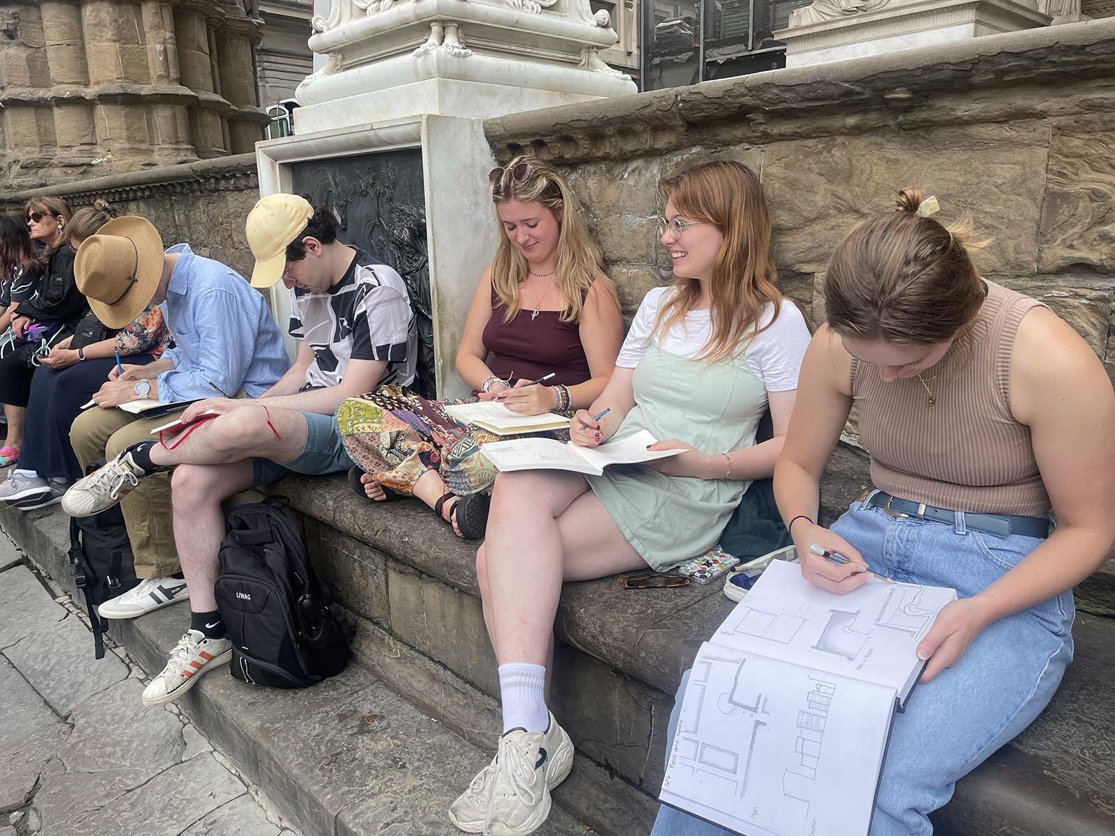 Students drawing on sketchbooks in Italy