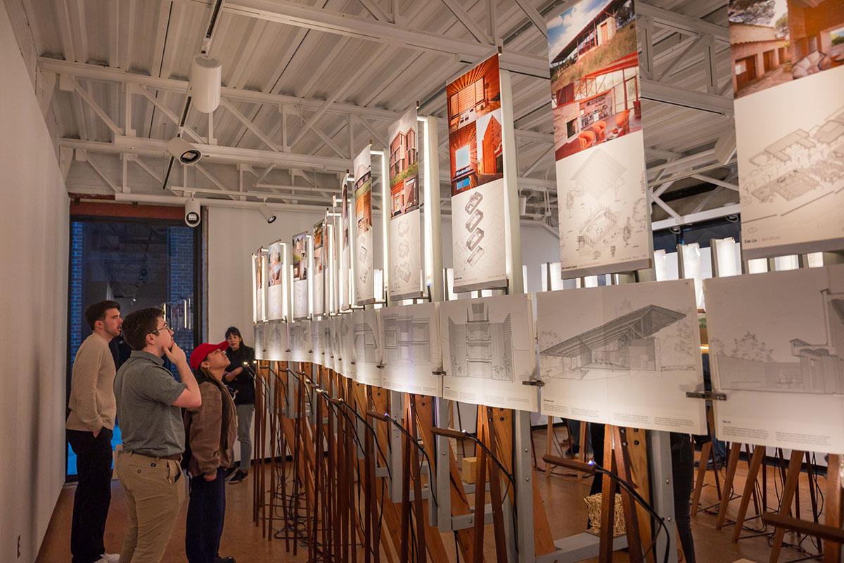 Students looking up at panels lit at an exhibition